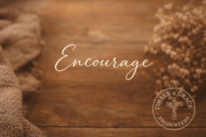 Encourage script overlaying a wooden table with flowers